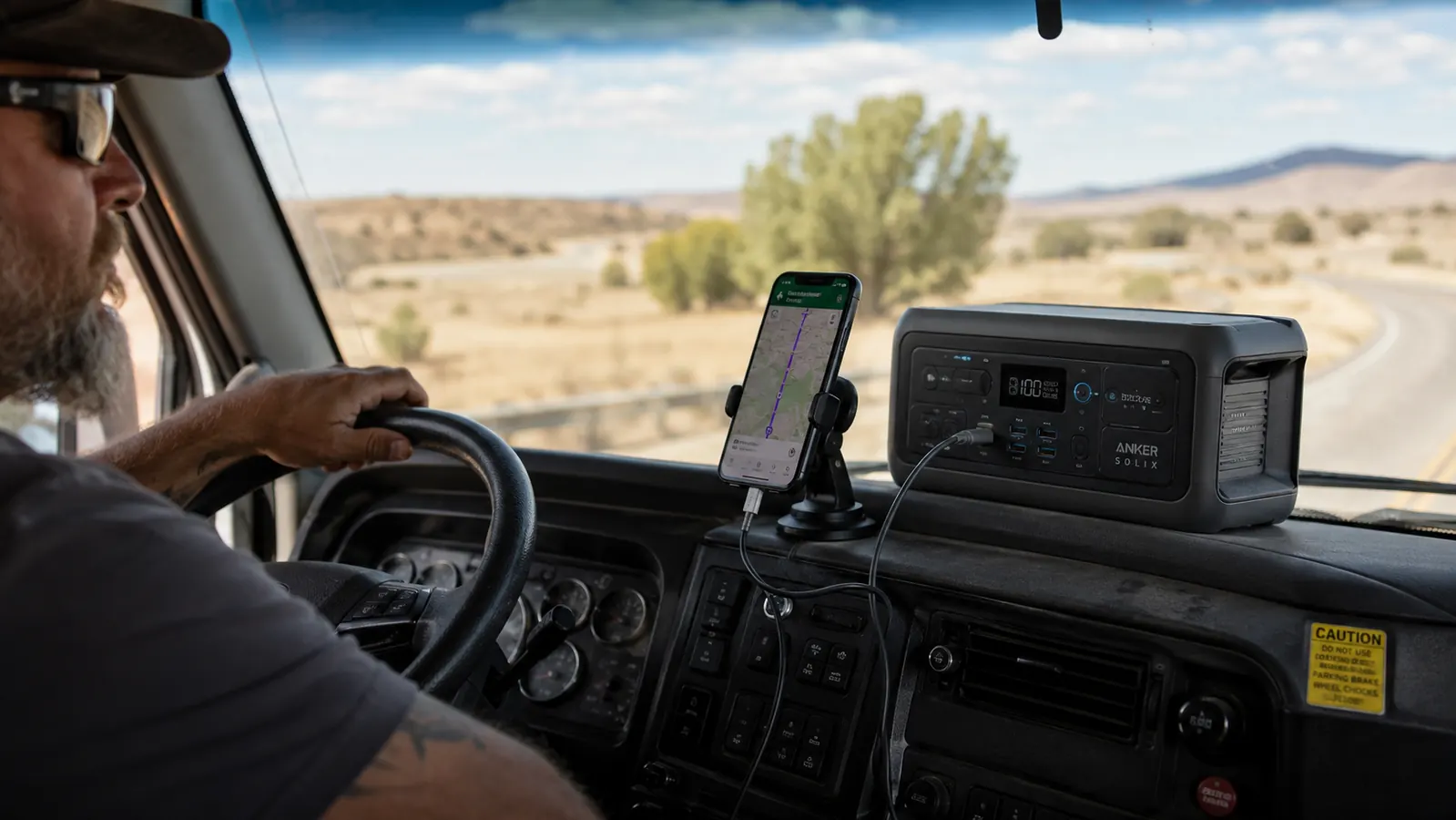 Power bank on a truck dash with a highway stretching ahead at dusk