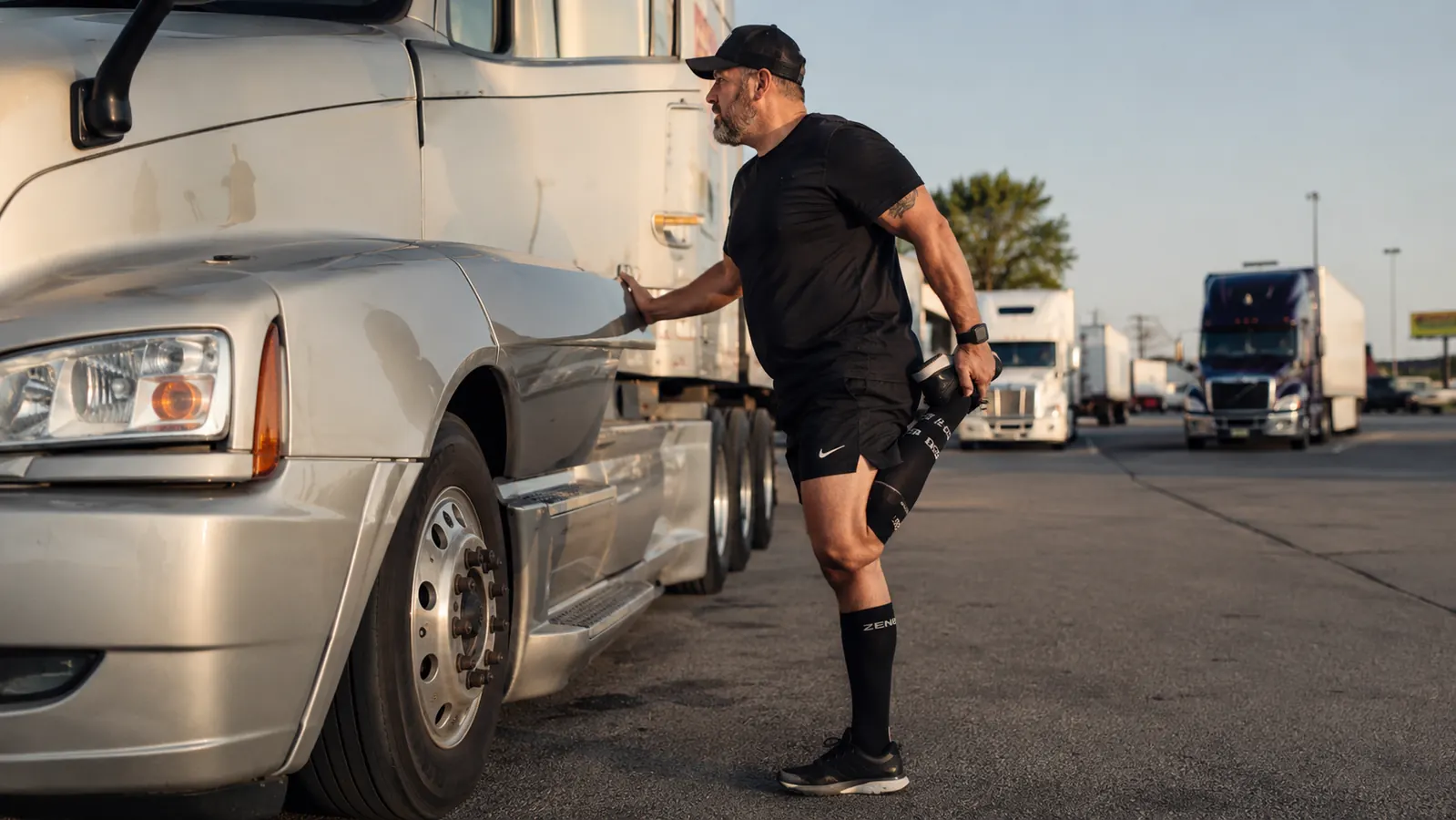 Driver's feet elevated on dashboard at a rest stop, compression socks visible